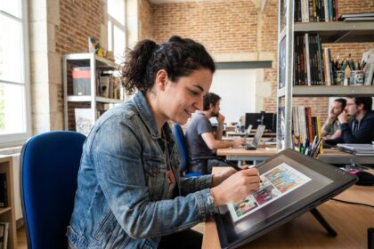 Jeune femme concentrée dessinant une bande dessinée dans un espace de coworking
